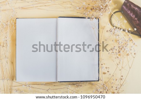 A book with blank page for copy and word on vintage prop with dried flower