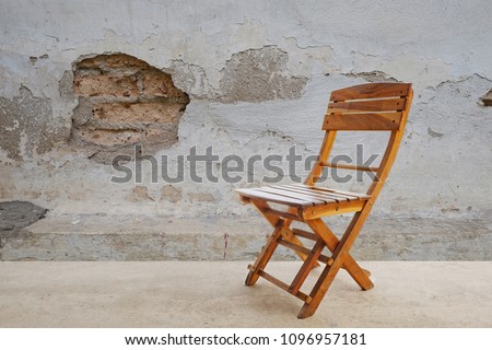 wood chair standing in empty interior, Old wall design in the background