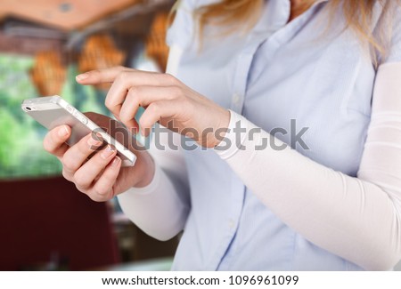 Happy woman using smartphone in cafe