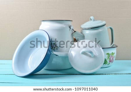 A lot of enameled dishes on a blue table. Retro style cookware
