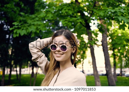 Beautiful smiling woman with glasses in the park                           