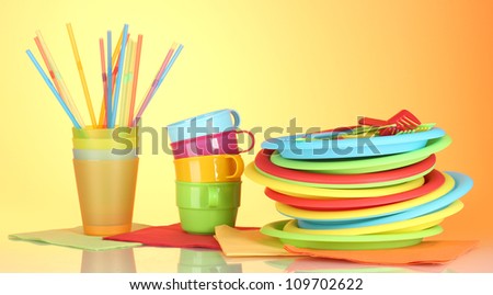 bright plastic disposable tableware on colorful background