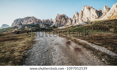 Dirt road and hiking trail track in Dolomites mountain, Italy, in front of Pizes de Cir Ridge mountain ranges in Bolzano, South Tyrol, Northwestern Dolomites, Italy. Royalty-Free Stock Photo #1097052539