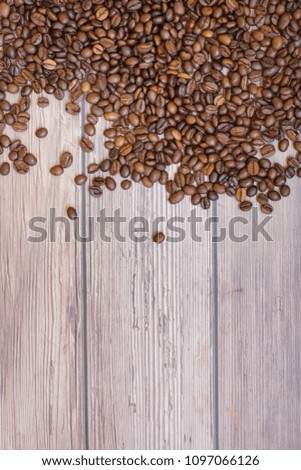 Coffee beans scattered on wood background top view with plase for text