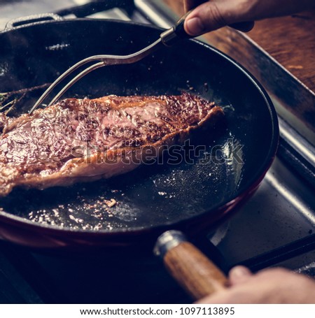 A chef cooking steak in a pan food photography recipe idea