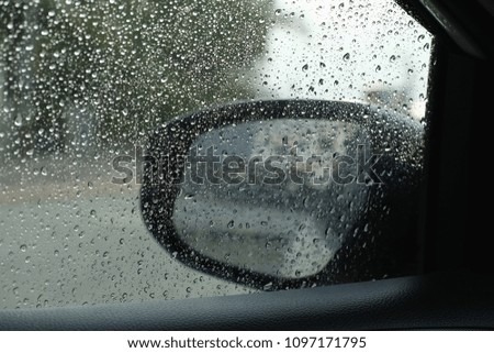 select focus rain drops on the car window and glass outside the car in the raining day