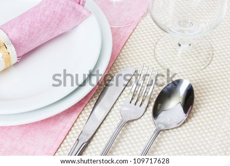 Table setting with fork, spoon, knife, plates, and napkin