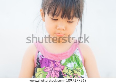 Sad asian little child girl on white background.