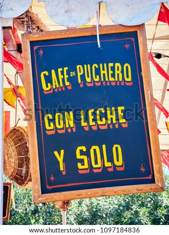 Vintage wooden signboard at a fair announcing coffee in Spanish; Pout coffee, Coffee with milk and Black coffee.