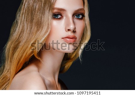 Young beautiful woman model with long beauty blonde curly hair portrait. Beautiful female girl with perfect healthy makeup and hairstyle. Studio shot.