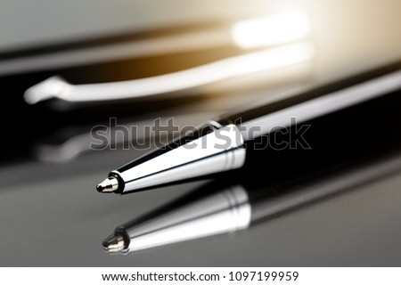 Close up black metal pen on dark background.
