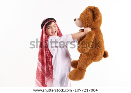 Arabian happy boy in keffiyeh hugs stuffed toy. Childhood concept. Isolated on white background.