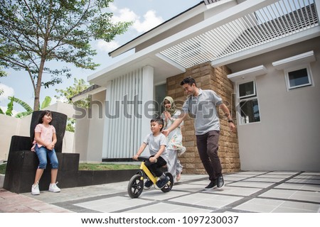 happy kid with his father learning how to ride a bicycle using push or balance bike Royalty-Free Stock Photo #1097230037