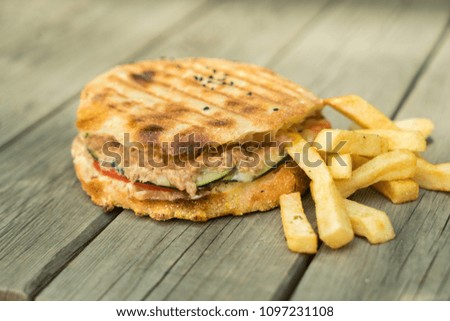 chicken burger with french fries on a wooden table