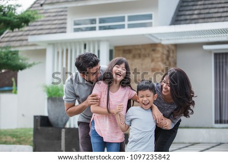 portrait of happy asian family in front of their new house Royalty-Free Stock Photo #1097235842