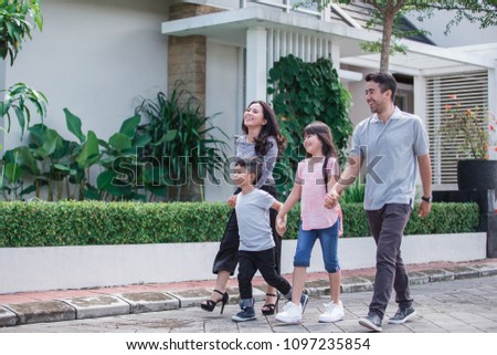 portrait of young asian family in their neighborhood walking around together Royalty-Free Stock Photo #1097235854