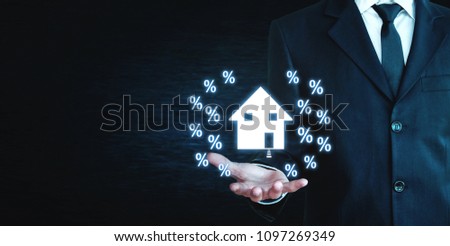 Man holding house and percent signs. 