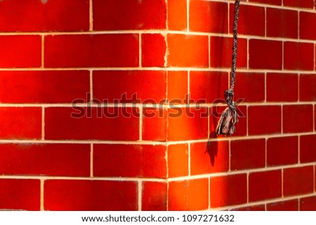 Hanging colourful cotton rope with reddish concrete wall background unique photo
