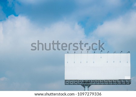 White bilboard with blue sky background.