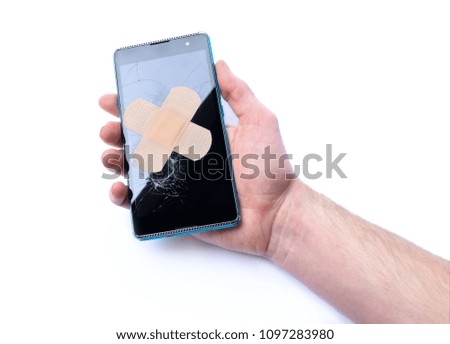 Smartphone with cracked display in hand and adhesive bandage. concept of repair phones. isolated on white background
