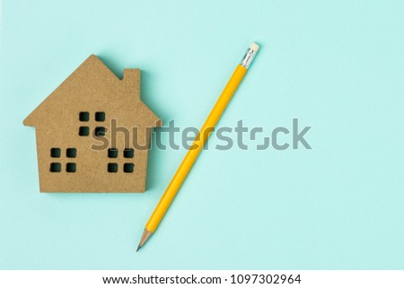 brown wood home icon and a pencil on blue background