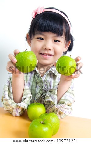 Little Asian child poses with green apple