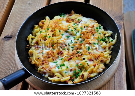 Schinken-Käsespätzle - Tyrolean noodles with bacon and cheese Royalty-Free Stock Photo #1097321588