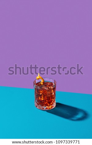 Negroni IBA cocktail, with gin, bitter, vermut, in pop contemporary style, colorful, dark background. Royalty-Free Stock Photo #1097339771