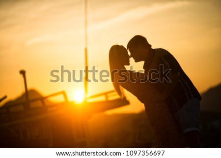 man and woman kissing at sunset. Silhouette photo