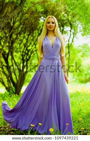 Awesome blonde woman in a long lilac dress