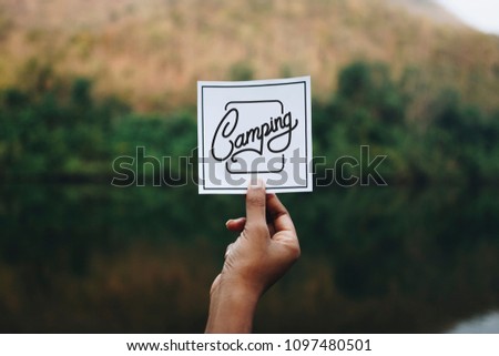 Traveler holding up a note in nature mockup