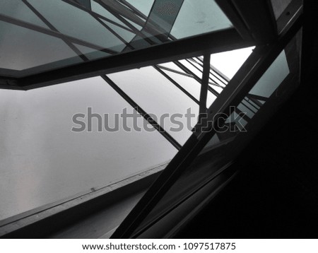 View form inside - Reflection cloud and overcast sky in window mirror of building - The steel structure with the glass window of office tower