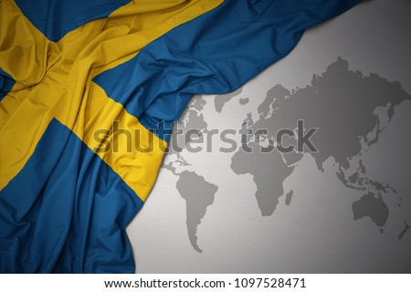 waving colorful national flag of sweden on a gray world map background.
