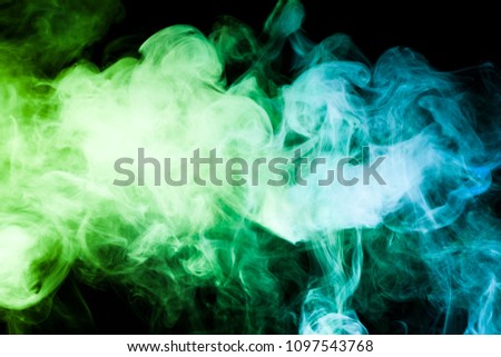 Dense multicolored smoke of  green and blue colors on a black isolated background. Background of smoke vape