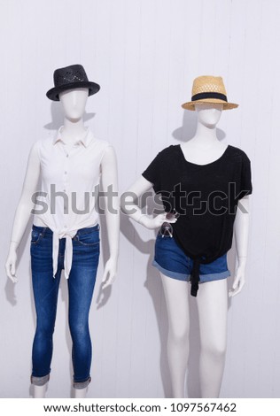 Two mannequin in female shirt with blue ,shorts jeans,sunglasses, ,hat, 
