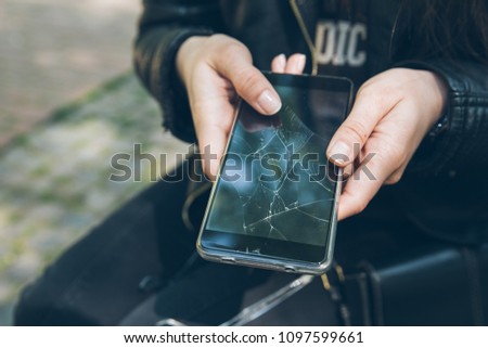 phone with cracked screen in hand. non warranty case