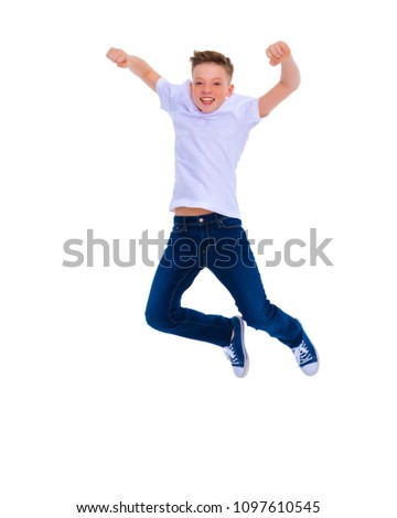 A little school boy jumping in the studio on a white background. The concept of joy, happy childhood. Isolated on white background.