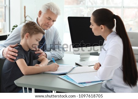 Senior man with his grandson having appointment at child psychologist office