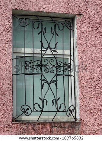 black metal forged carved lattice at a white window