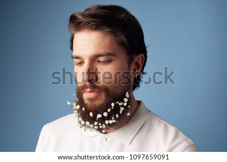 A man with dots on his beard looks down                           