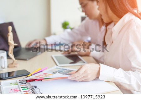 Asia Graphic designer working on computer tablet and Coloring device in studio office.
