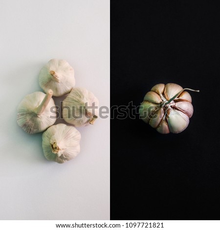 garlic whole and half on white and black background