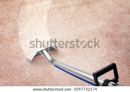 Removing dirt from carpet with professional vacuum cleaner indoors Royalty-Free Stock Photo #1097732174