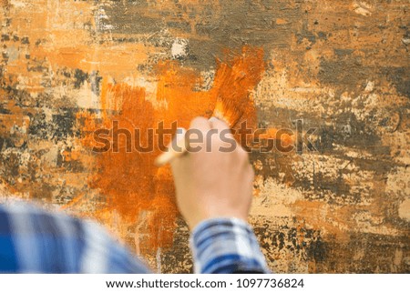 Asian man painting on canvas.