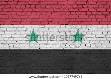 Syria flag is painted onto an old brick wall