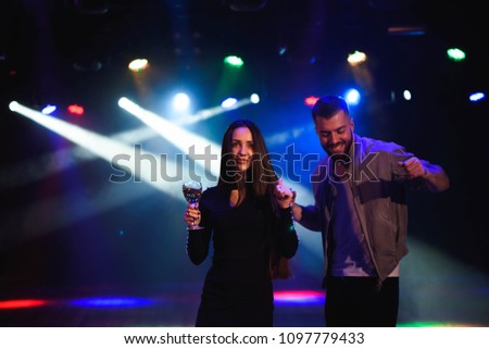 Image of happy young couple having fun at disco. Young man and woman enjoying a party.