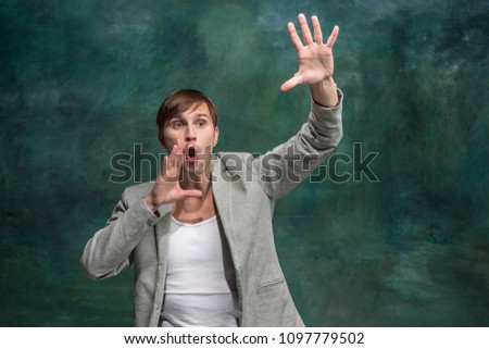 Do not miss. Young casual man shouting. Shout. Crying emotional man screaming on studio background. male half-length portrait. Human emotions, facial expression concept.