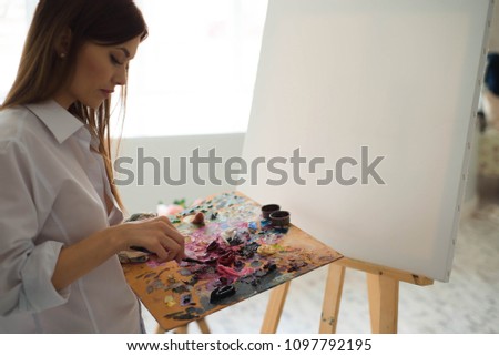 Young female student having classes at art studio, learning how to draw flowers