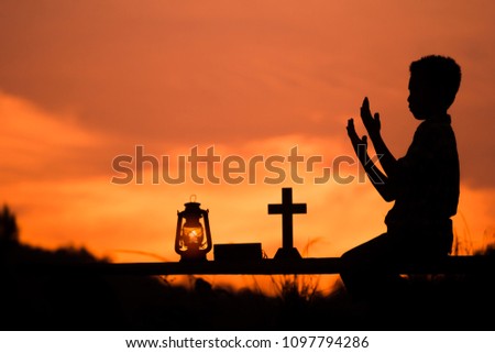 Boy worship and praying to god with oil lamp, christian concept