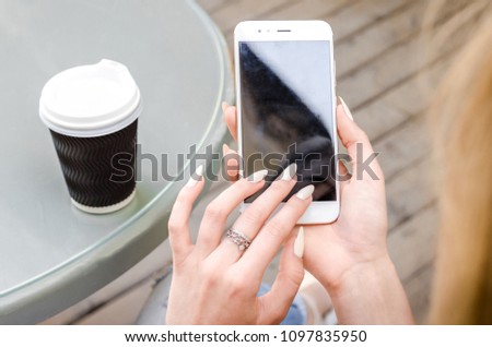 Close Up white Smartphone Mobile Cell holding in woman hands  Stylish Torn Jeans Long Nails Denim Black Oled Display Stone Background Royalty-Free Stock Photo #1097835950